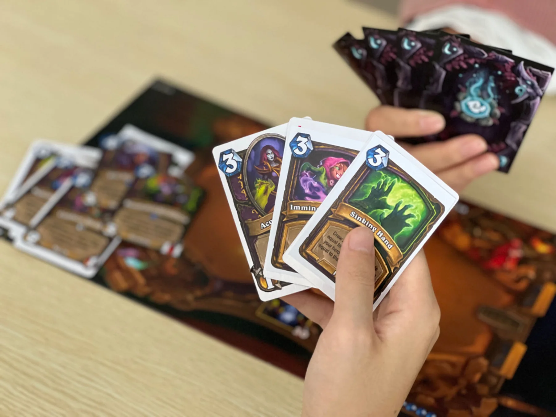 A hand of printed cards being read during a paper playtest.